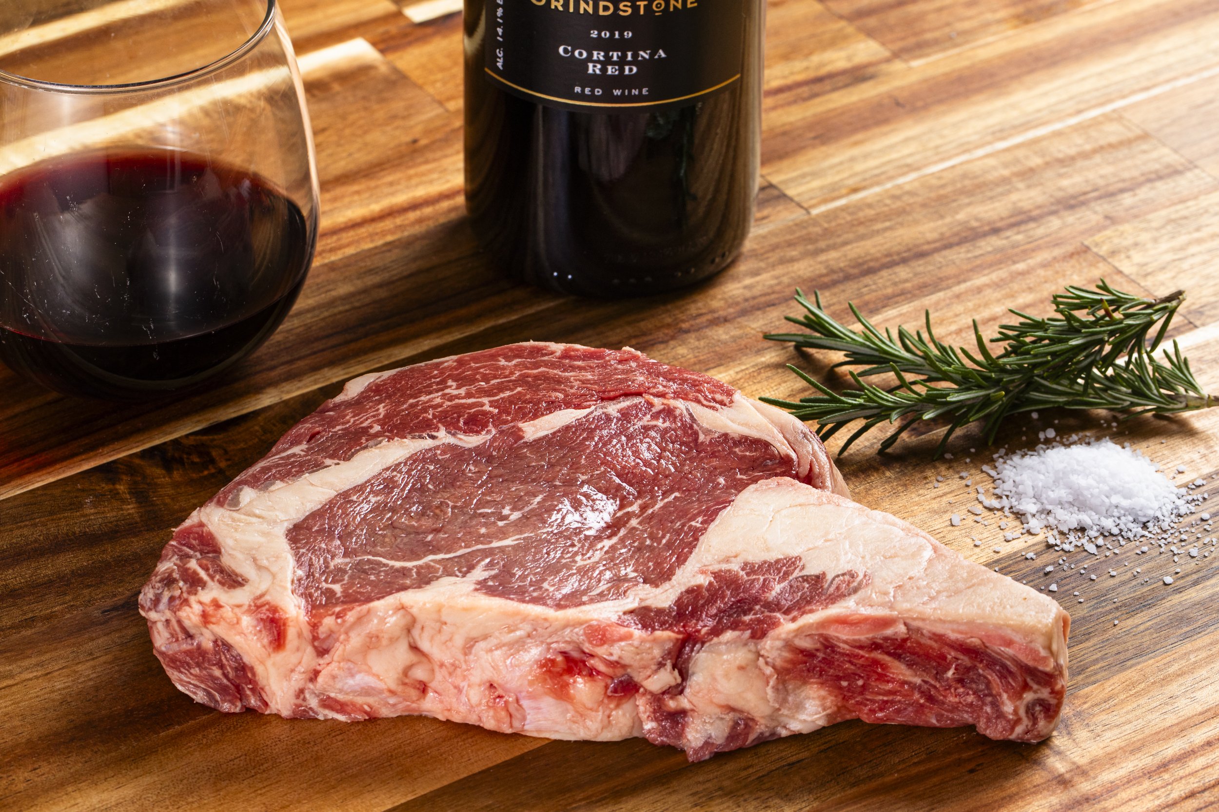 Ribeye on a wooden board with rosemary